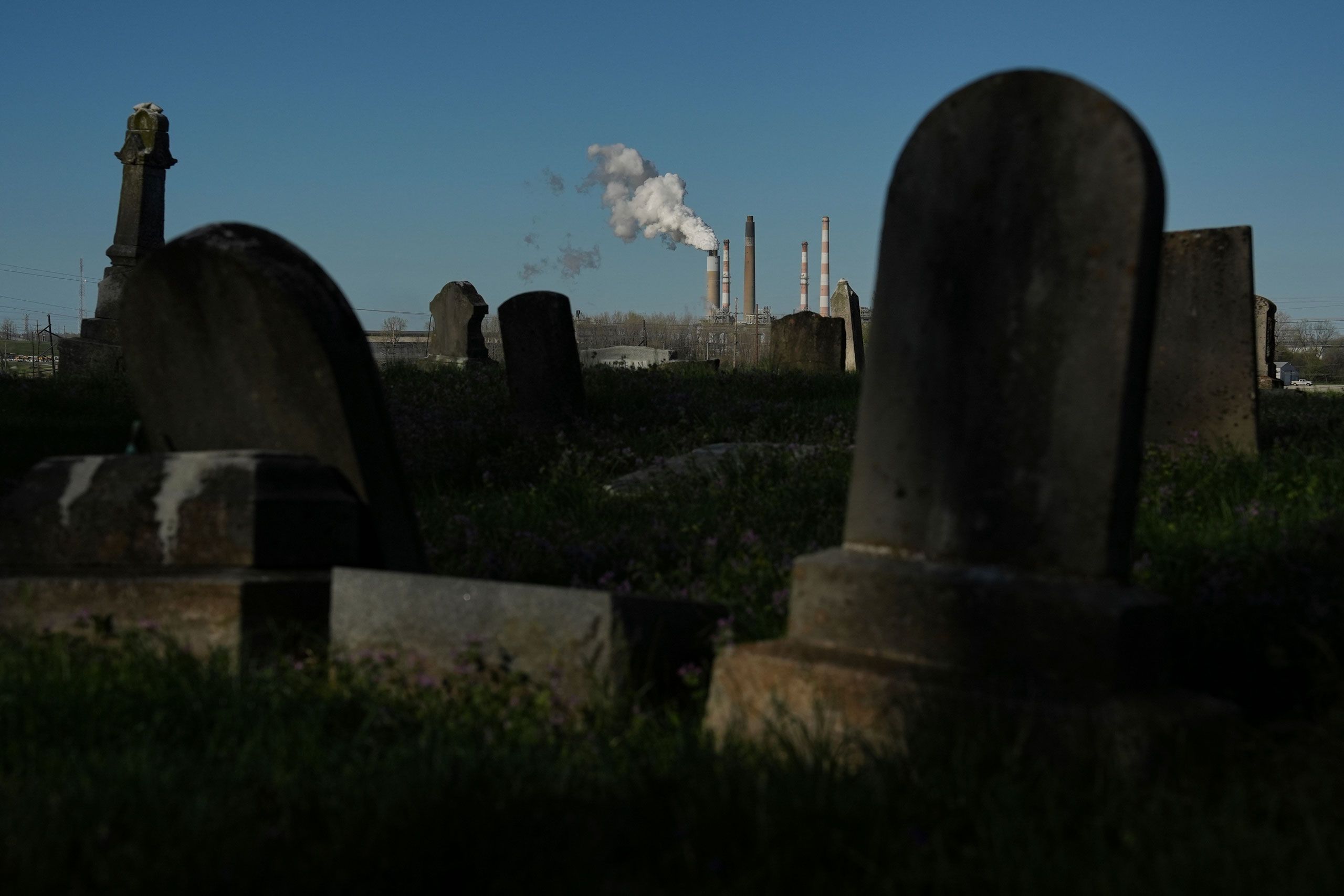 A photo of a power plant seen from a cemetery.